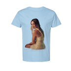 Light blue t-shirt, front view, with a photo print of Hilary Duff in a beige dress seated on sand