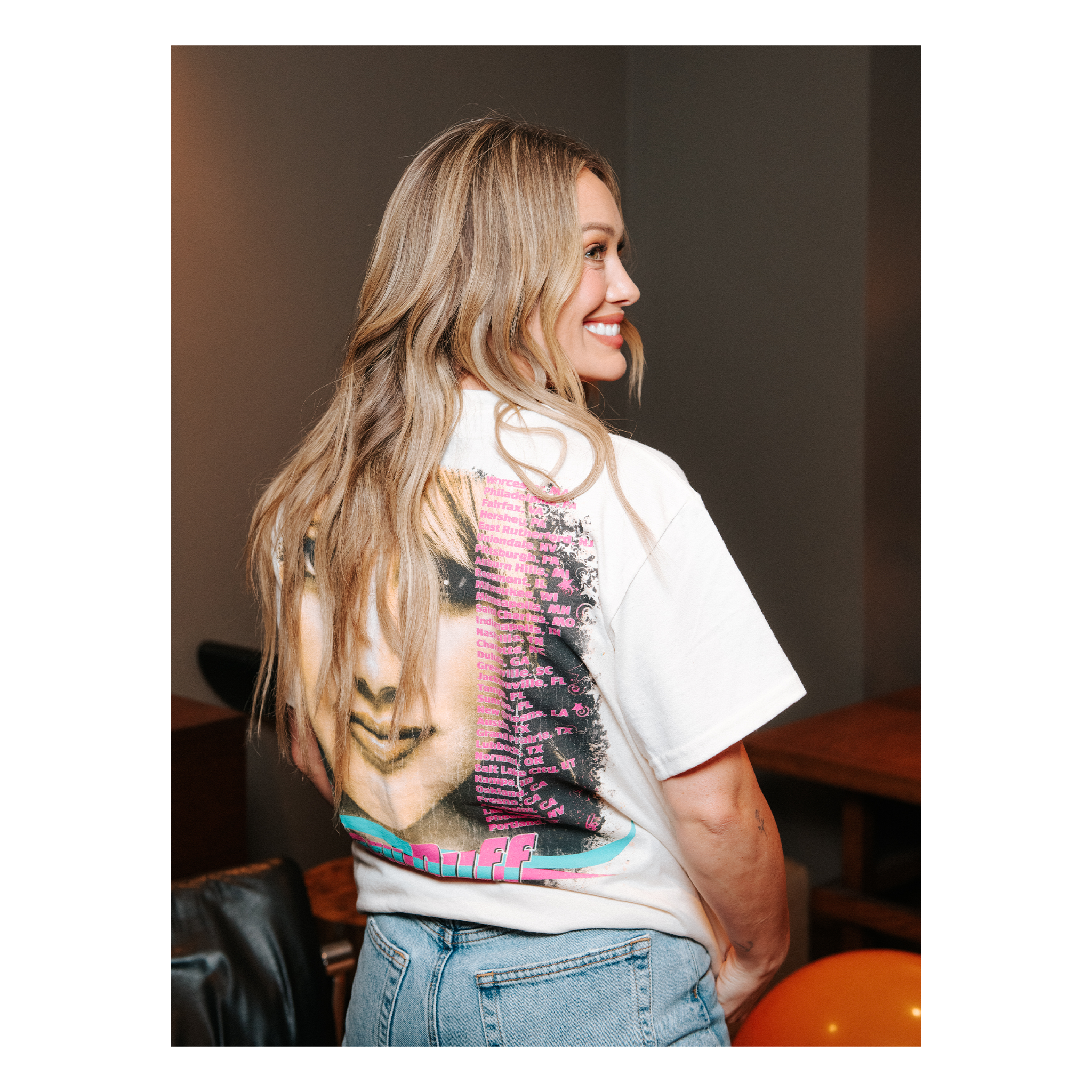 Model wearing a cream Hilary Duff Tour 2004 t-shirt, back view showing the photo graphic and logo lettering